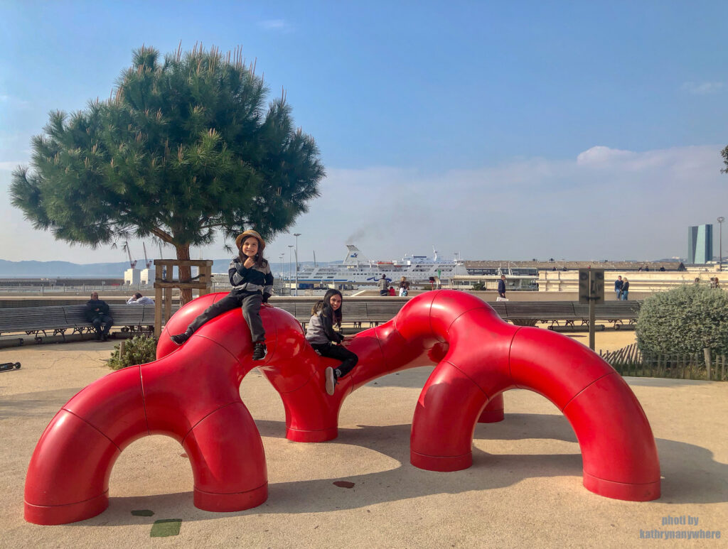 my children playing in a kid's playground in the old port area of Marseille, France