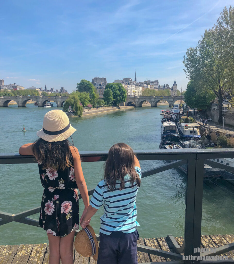 Miss M and Little Man looking at Notre Dam right after the fire on the bridge over the River Seine.