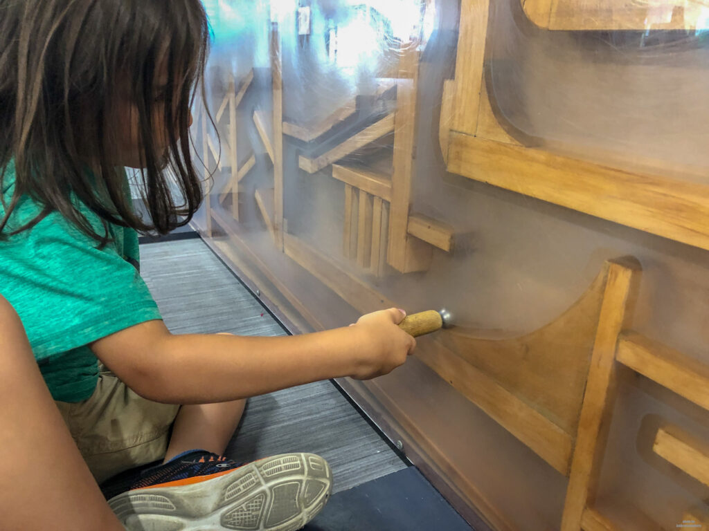 Little Man playing with a magnet and a metal ball in Discovery Space - a great place for kids to explore science and mechanics in State College, PA
