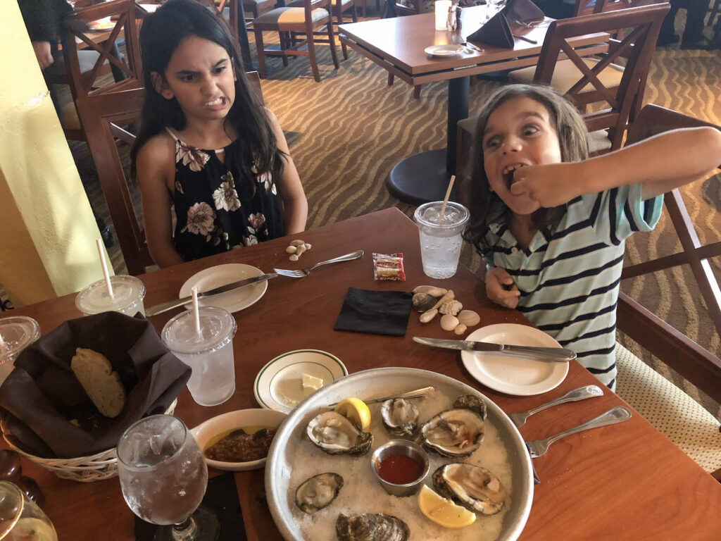 Little Man eating oysters at Traditions On The Beach at Island Inn, Sanibel Island