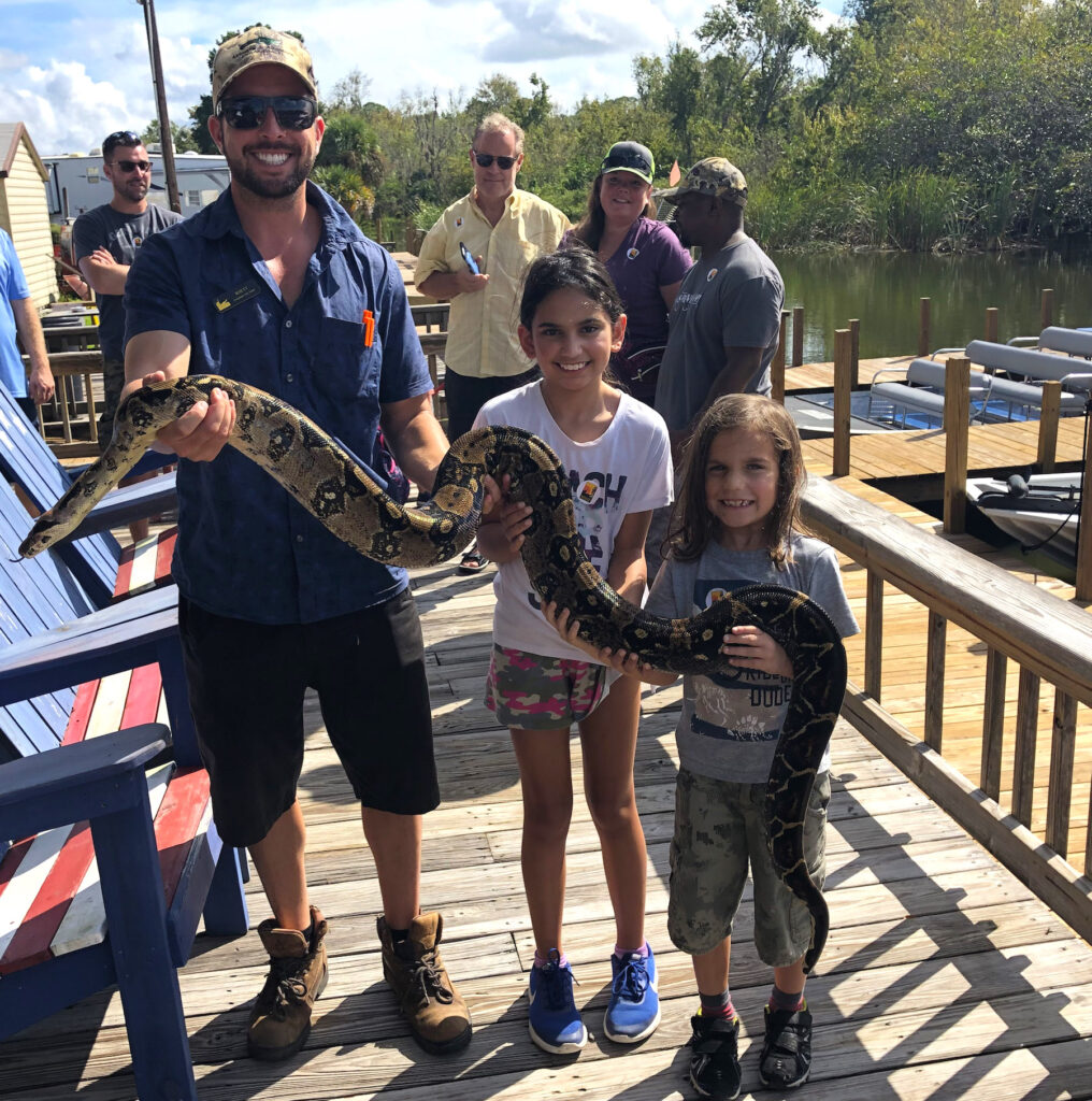 Miss M and Little Man holding a boa with Rhett, our day safari guide