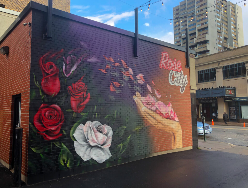 Did you know that Windsor, Ontario is known as the Rose City? Windsor was chosen to promote the heritage of new English settlers in the city and to recognize Windsor Castle in England. Straight up, Windsor has a reputation for being gritty and scrappy. Although lately it’s going through a period of regrowth. No longer only known for auto manufacturing, the downtown core has some modern and trendy bars and restaurants going up. This amazing mural can be found in WIFF Alley!