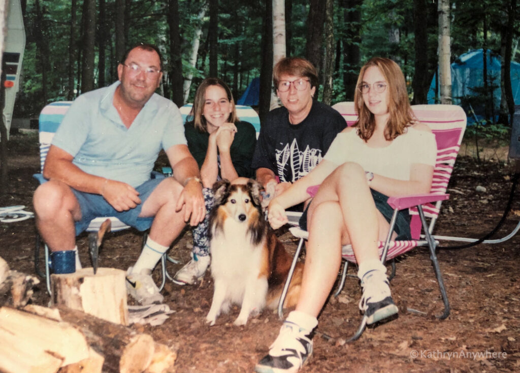 family at campfire with dog