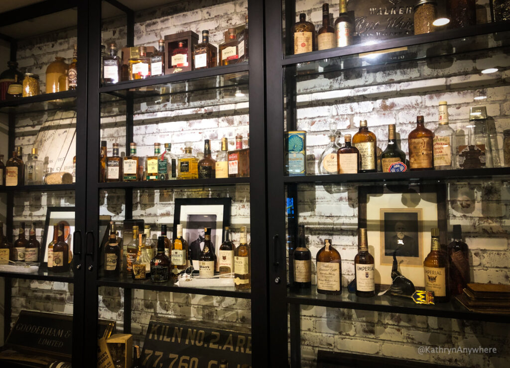 Selection of whisky bottles throughout history in J.P. Wiser's distillery bar in the shop. The Hiram Walker whisky tour starts here.