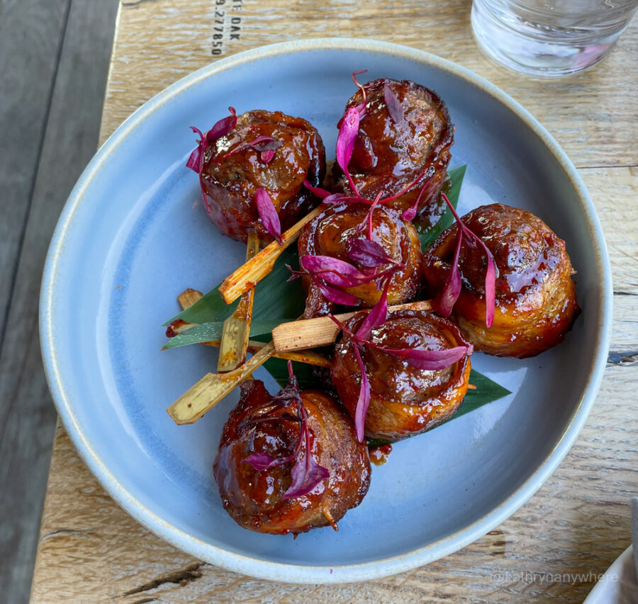 Beef Taksune, Bacon wrapped beef balls with Gochujang BBQ sauce, comes with a cold bottle of Estrella Damm at Harriet's rooftop bar 