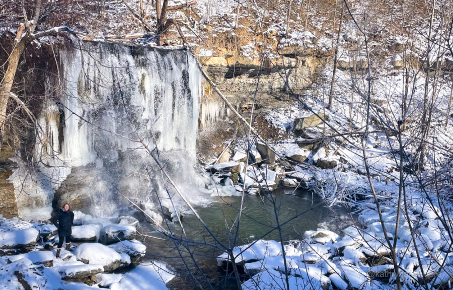Activities Outside in Winter. Adventurous Backpacker Girl Hiking and Climbing to high mountains alone. Extreme Sports. Waterfall Chasing. Frozen waterfalls. Winter Hiking Tips.