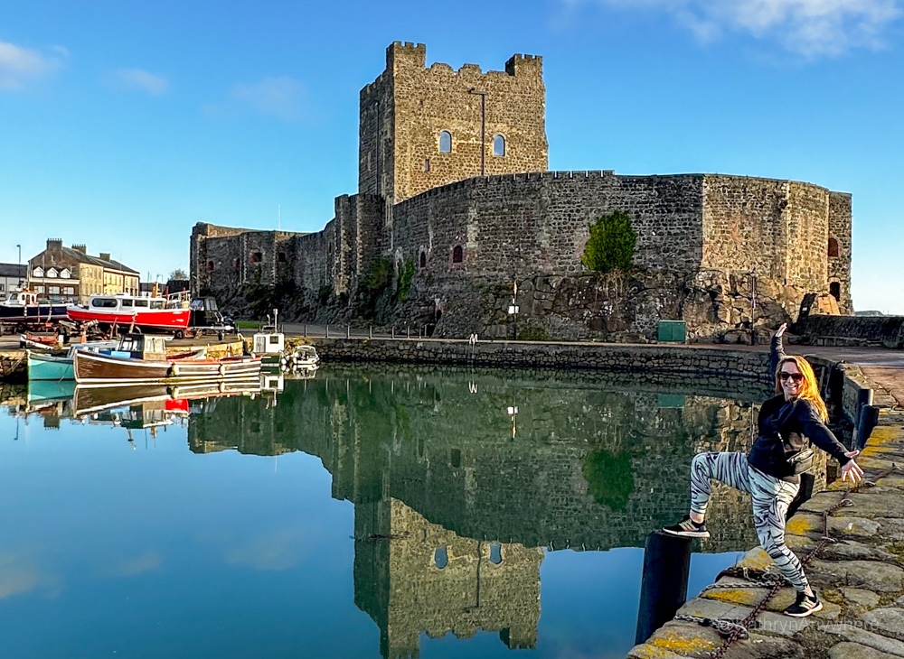 CarrickFergus Castle in Northern Ireland with the author in front at the harbour