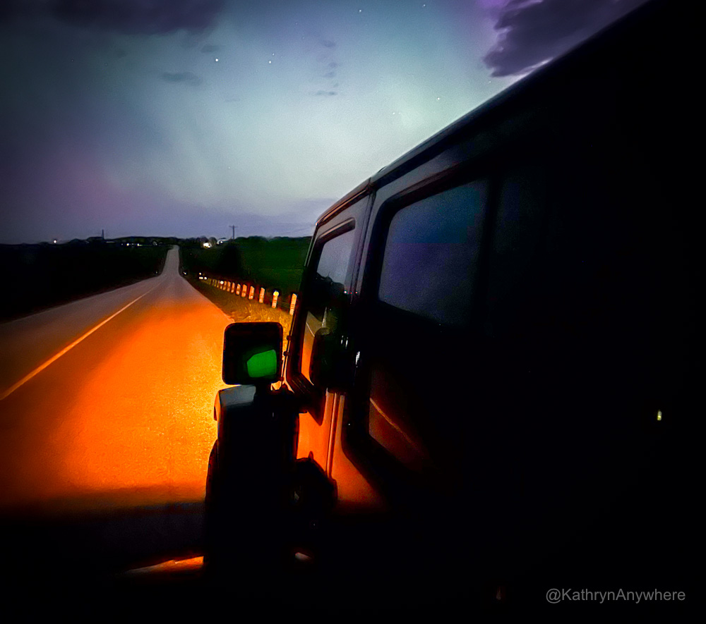 Jeep on a dark road under northern lights - great place to have sex