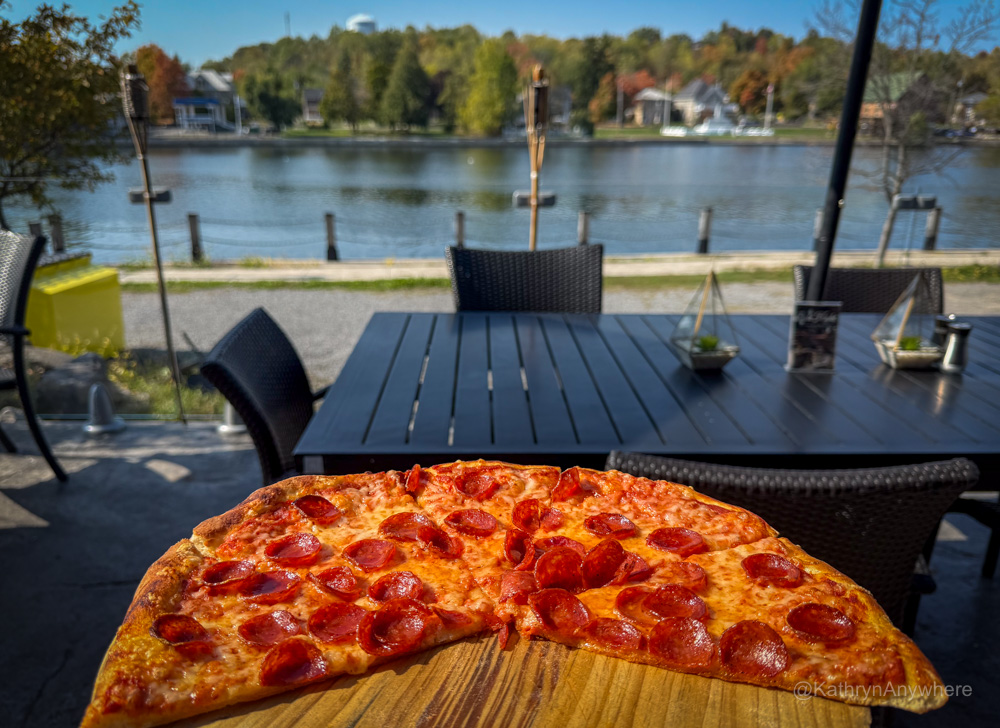 Things To Do in Campbellford - Dine on the Patio at Nicki’s Resto Patio. Pepperoni pizza in foreground, trent river in background.